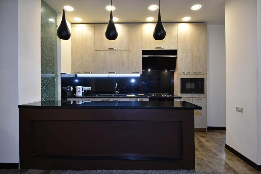 una cocina con una gran isla negra en el medio en Rent Inn Yerevan on Sakharov Square, en Ereván