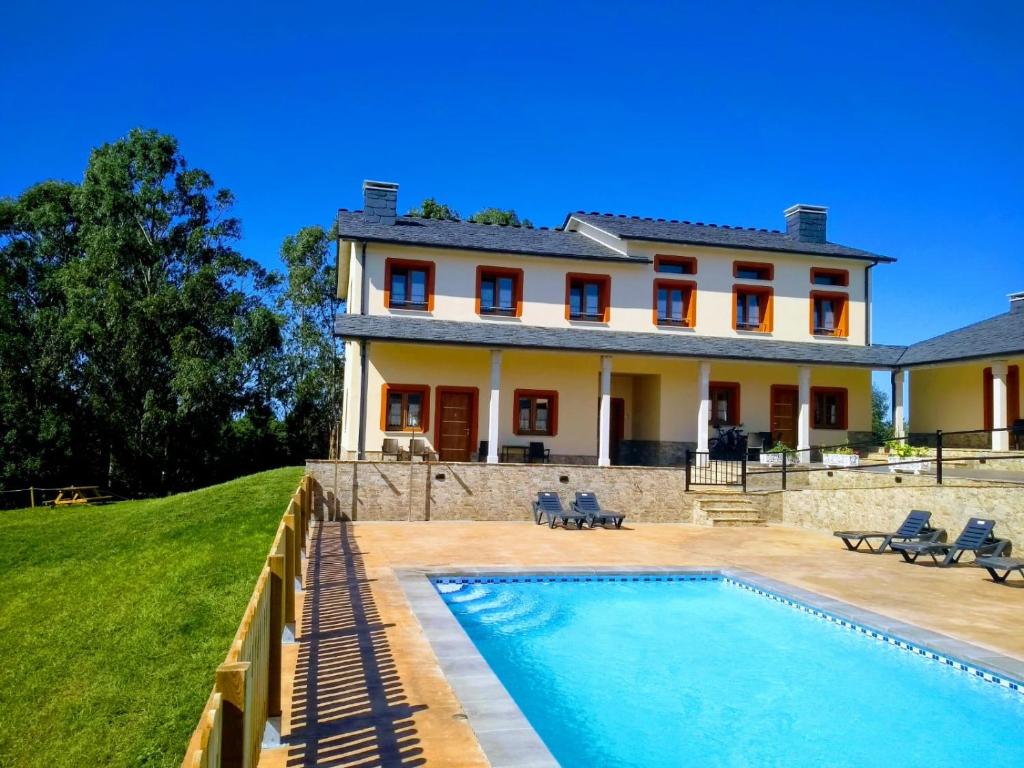 a house with a swimming pool in front of a house at Apartamentos Navalin in Tapia de Casariego