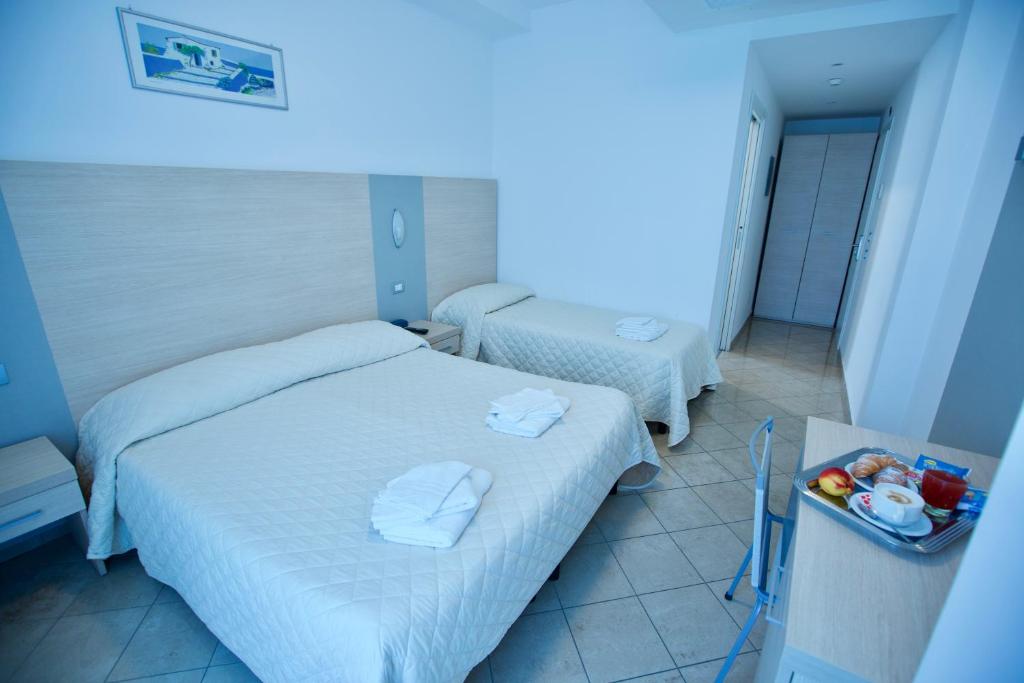 una camera d'albergo con due letti e una luce blu di Hotel Etoile a Rimini