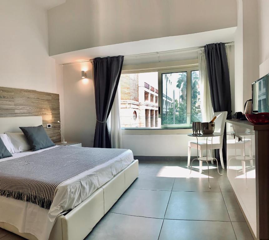 a bedroom with a bed and a desk and a window at MyB in Naples