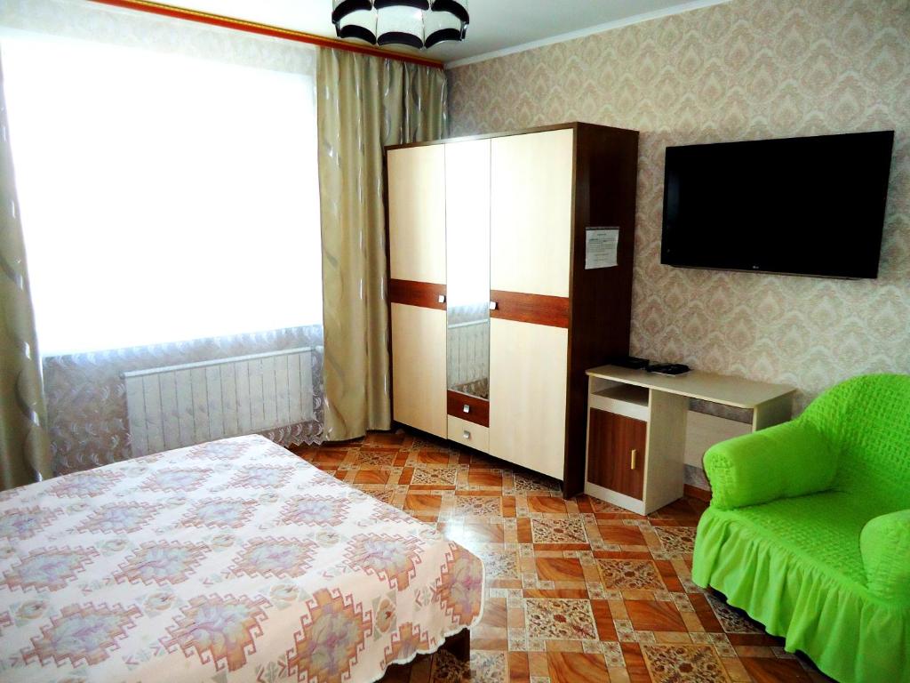 チタにあるApartment TwoPillows Krasnoarmeyskya 14 13flのベッドルーム(ベッド1台、テレビ、椅子付)