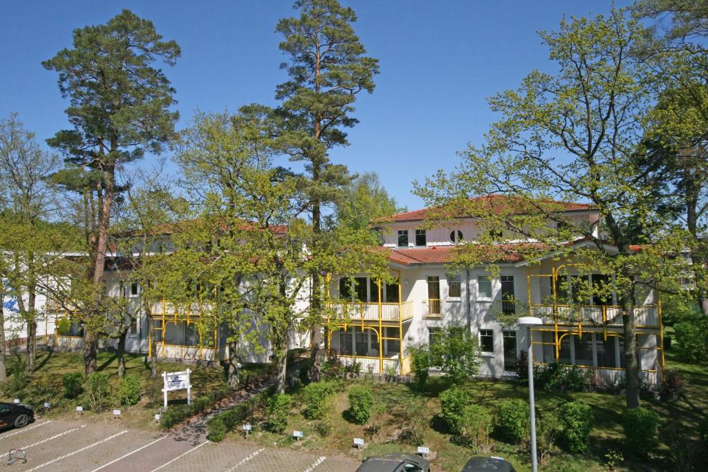 uma grande casa branca com estacionamento em Villa Stoertebeker - Ferienwohnung 17 em Baabe