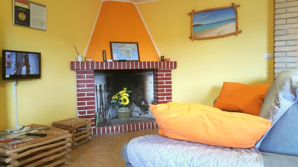ein Wohnzimmer mit einem Kamin und einem Sofa in der Unterkunft Vacanze Mare Teulada in Teulada