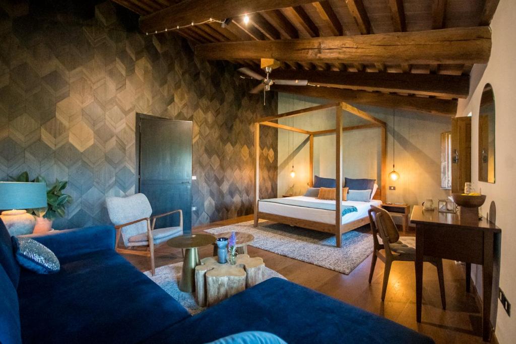 un soggiorno con divano blu e letto di Borgo Castello Panicaglia a Nocera Umbra