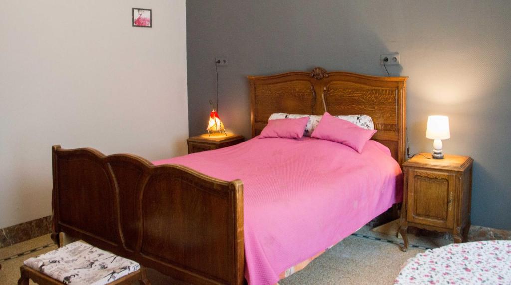 ein Schlafzimmer mit einem rosa Bett mit zwei Nachttischen in der Unterkunft B and B Comme chez soi in La Hestre