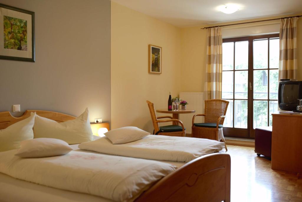 um quarto com 2 camas, uma mesa e uma janela em Weingut Schilling em Seinsheim