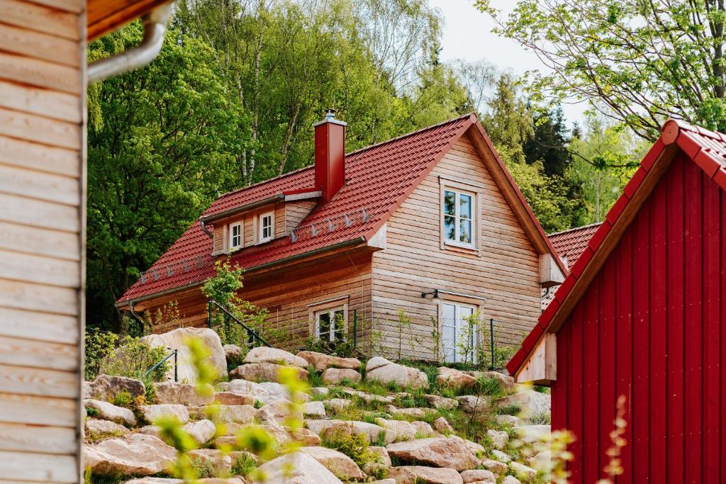 a house with a red roof and a red barn at Das Schierke Harzresort in Schierke