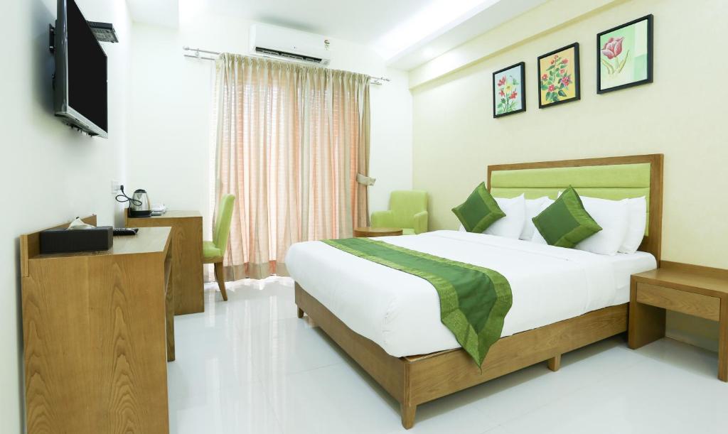 um quarto de hotel com uma cama e uma televisão em Treebo Trend The Galaxy Chandapura em Bangalore
