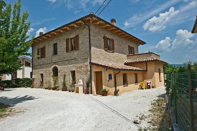 a large stone house on a dirt road at Antica Loggia in Fabriano