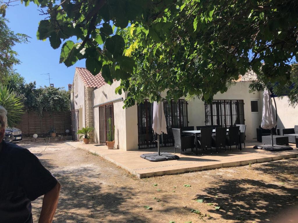 un groupe de chaises et une table avec des parasols dans l'établissement Clos Des Plages Maison De Vacances, à La Ciotat