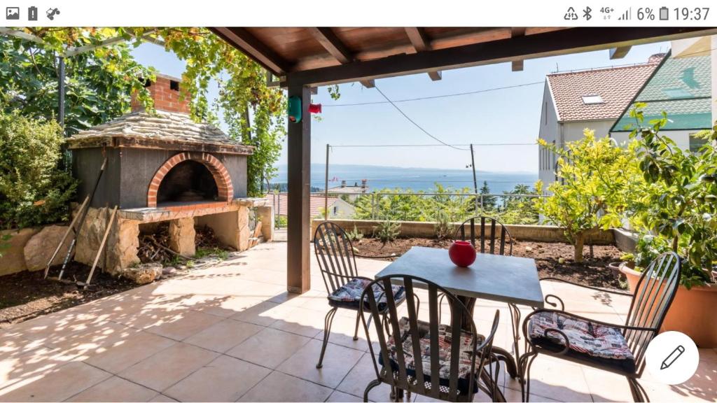 eine Terrasse mit einem Tisch und Stühlen sowie einem Pizzaofen in der Unterkunft Marjan Hill in Split