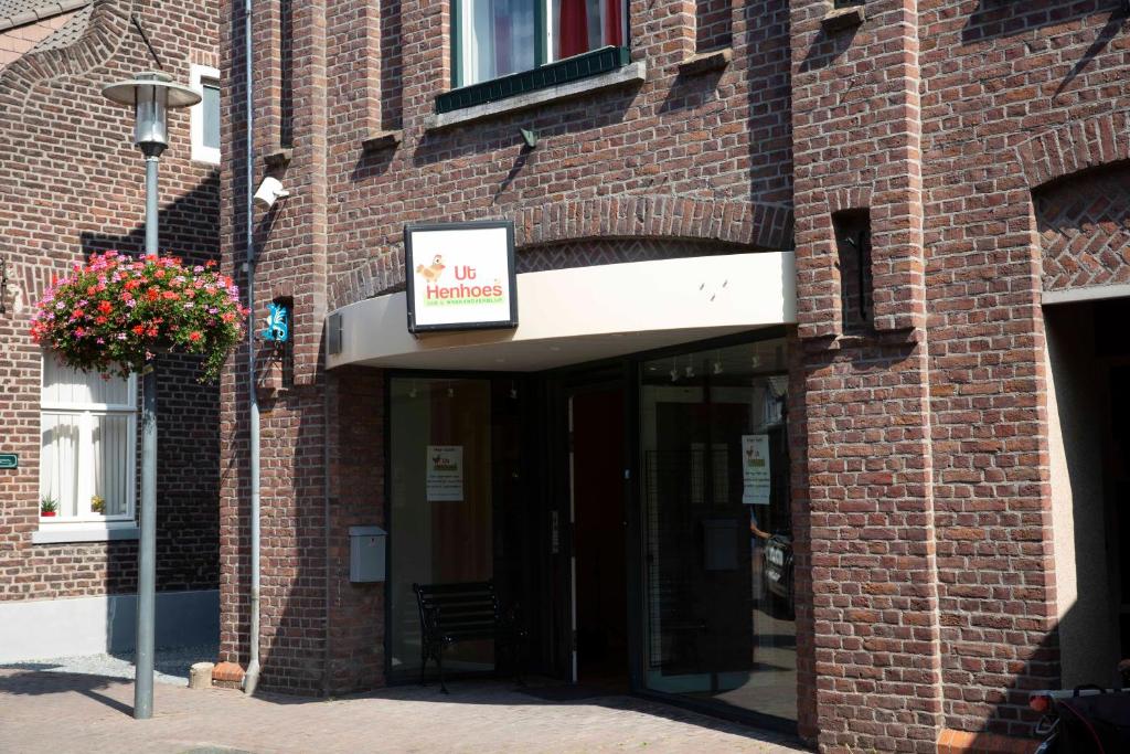 una entrada a un edificio de ladrillo con un cartel en él en ut Hen Hoes en Swalmen