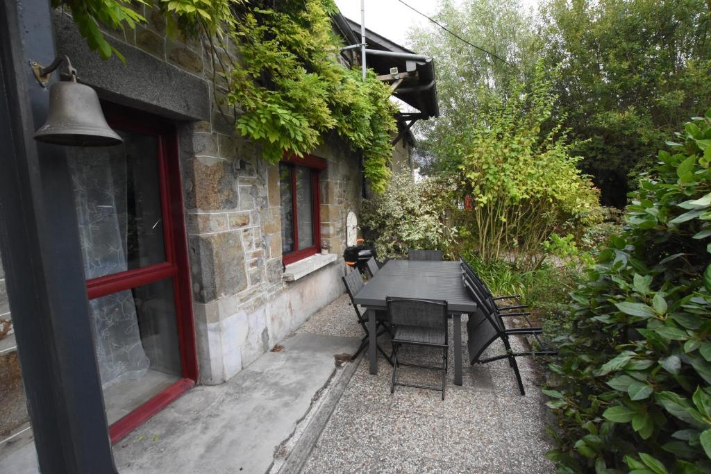 un patio avec une table et des chaises à côté d'un bâtiment dans l'établissement Le Domaine du Sillon, à Mont-Dol