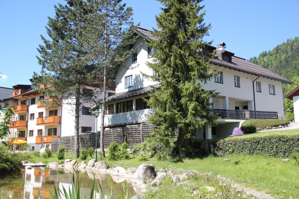 a house in the mountains next to a river at Apartments Gamsfeld in Russbach am Pass Gschütt
