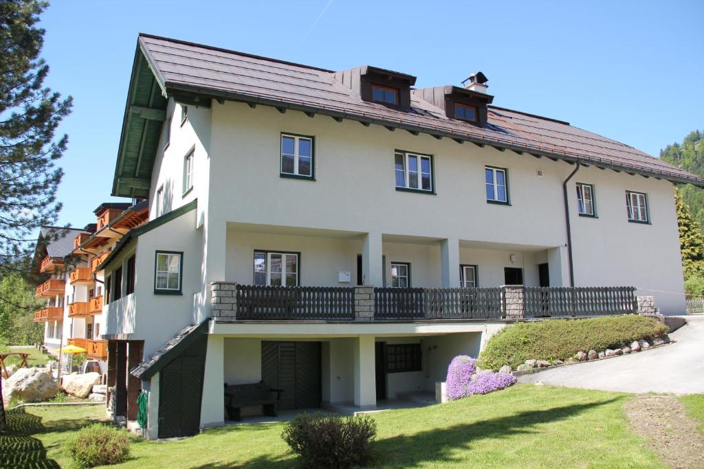 a large white house with a balcony at Apartments Gamsfeld in Russbach am Pass Gschütt