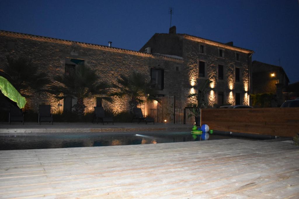 - un bâtiment avec une piscine en face de lui la nuit dans l'établissement Appartement + terrasse à 5 mn de Carcassonne, à Pezens