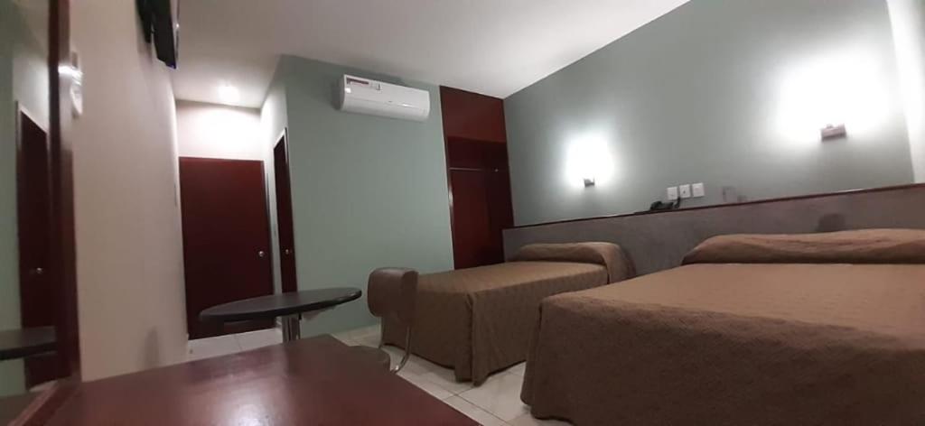 ein Hotelzimmer mit einem Bett, einem Stuhl und einem Tisch in der Unterkunft Hotel San Juan Periferico in Villahermosa