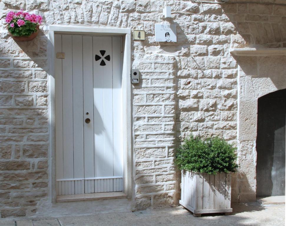 テルリッツィにあるB&B da Tiffanyの白い扉と植物のある石造りの家