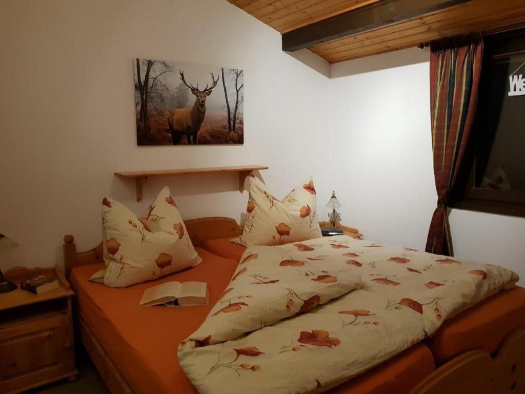 1 dormitorio con 1 cama con una foto de ciervo en la pared en Haus Ani Winterberg en Winterberg