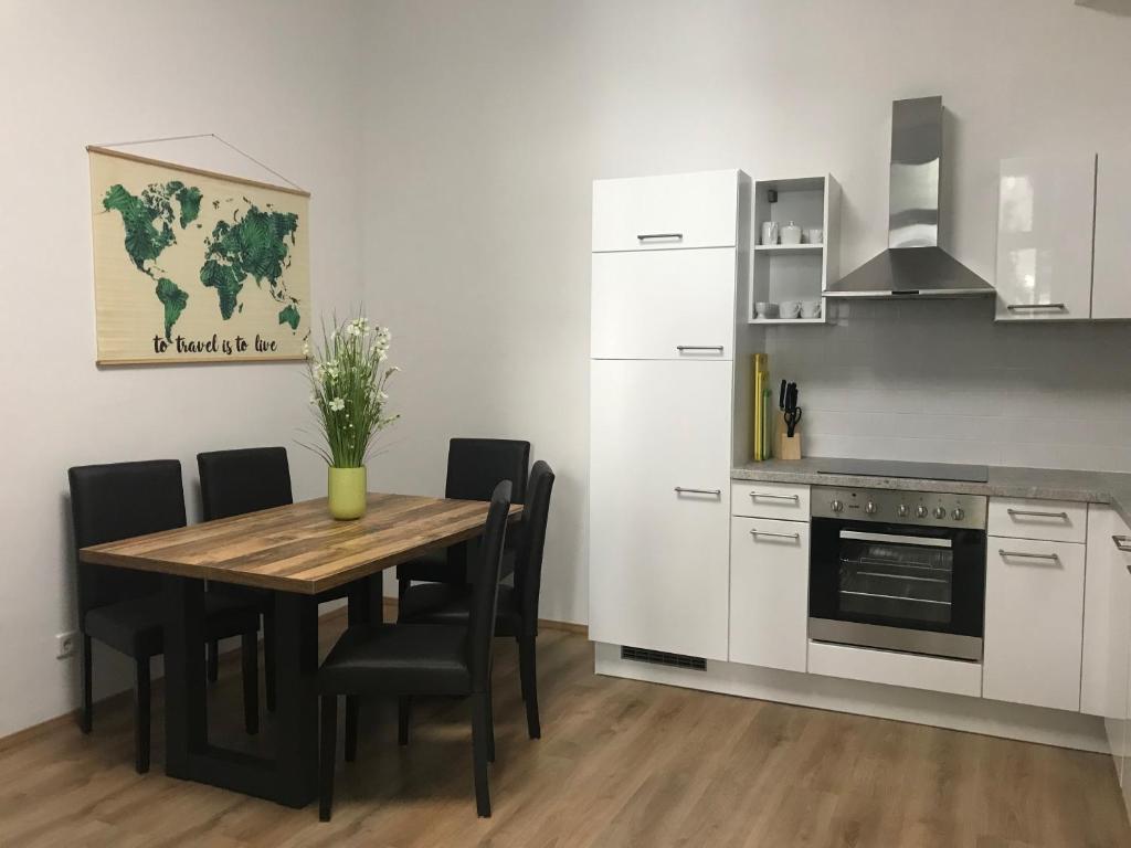 eine Küche mit einem Tisch und Stühlen sowie einem Kühlschrank in der Unterkunft Imperial Apartments Schönbrunn - Jadengasse in Wien