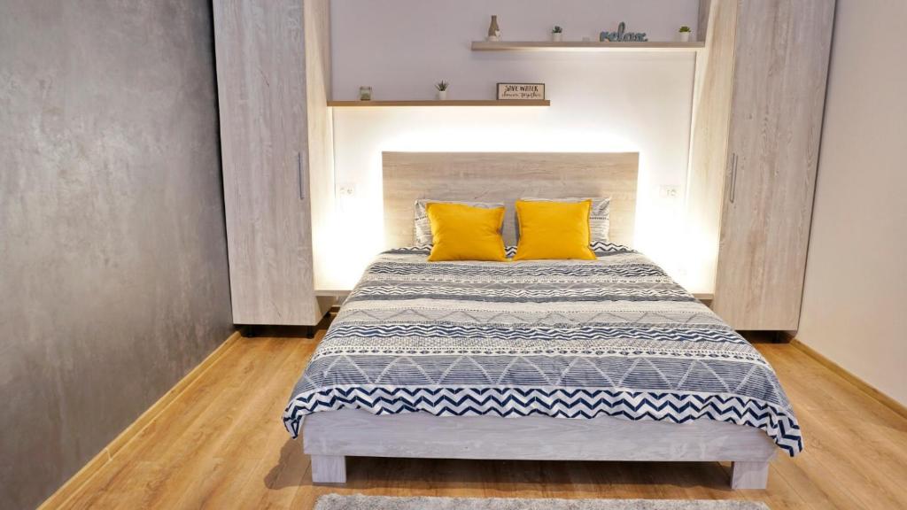 a bedroom with a bed with two yellow pillows at Jules Studio Downtown in Braşov