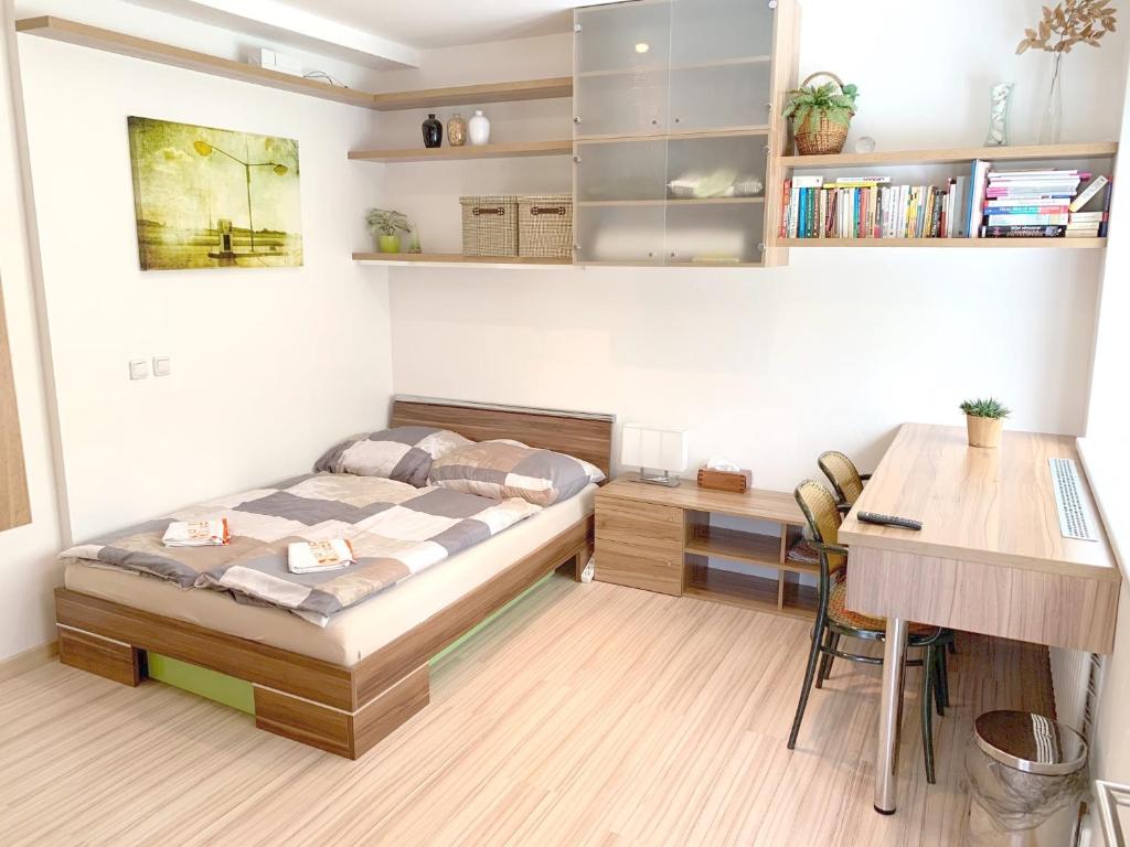 een kleine slaapkamer met een bed en een bureau bij Krásný apartmán u lesa blízko centra a BVV in Brno