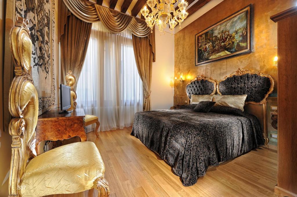 una camera con letto e lampadario a braccio di Ca Dell'Arte a Venezia