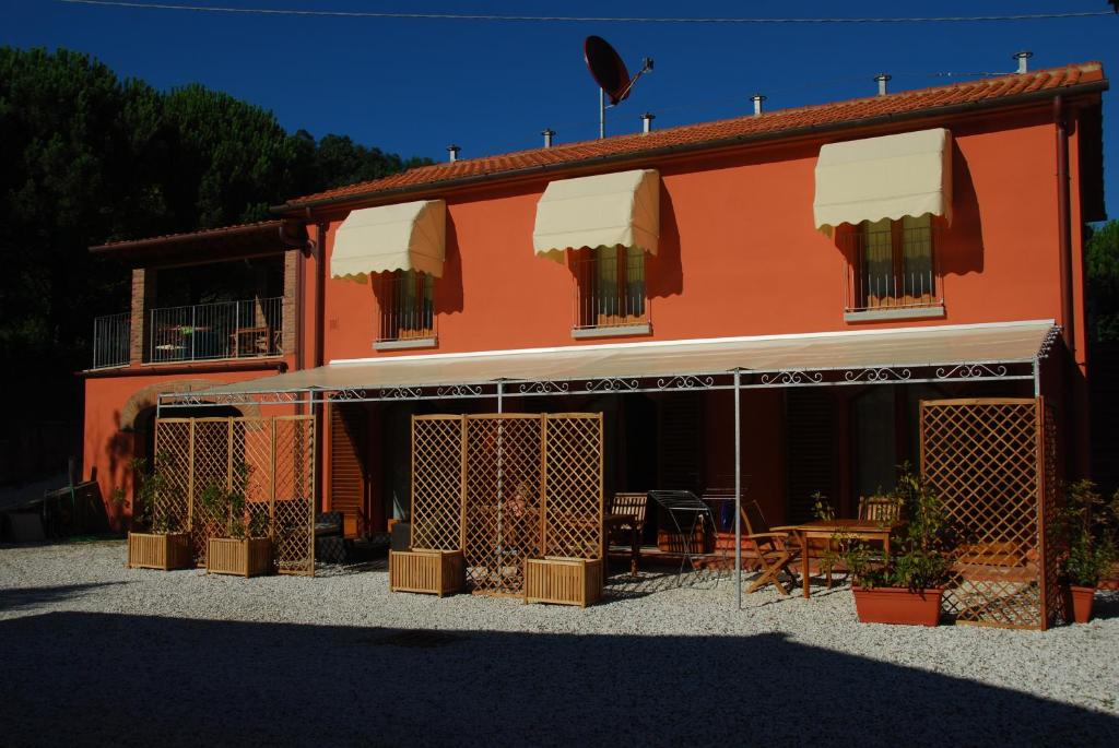 una casa arancione con un tavolo e sedie di fronte di Agriturismo Il Cantastorie a Montecatini Terme