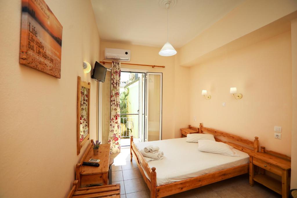 een slaapkamer met een bed en een groot raam bij Europe Hotel in Corfu-stad