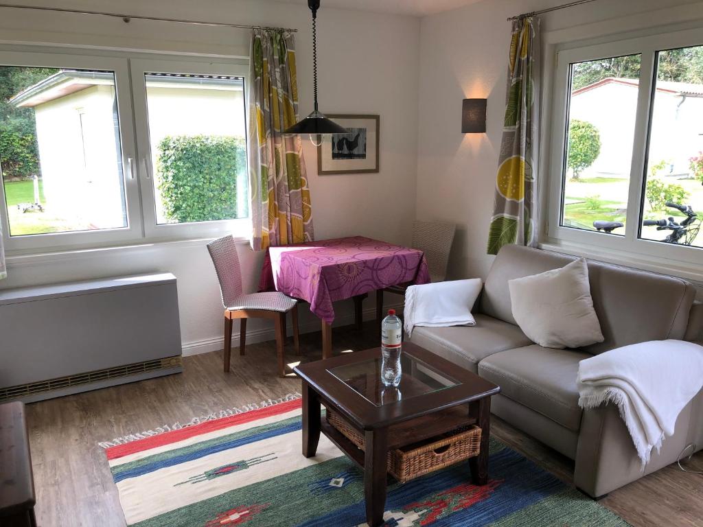 uma sala de estar com um sofá e uma mesa em Bungalow 3 em Wyk auf Föhr
