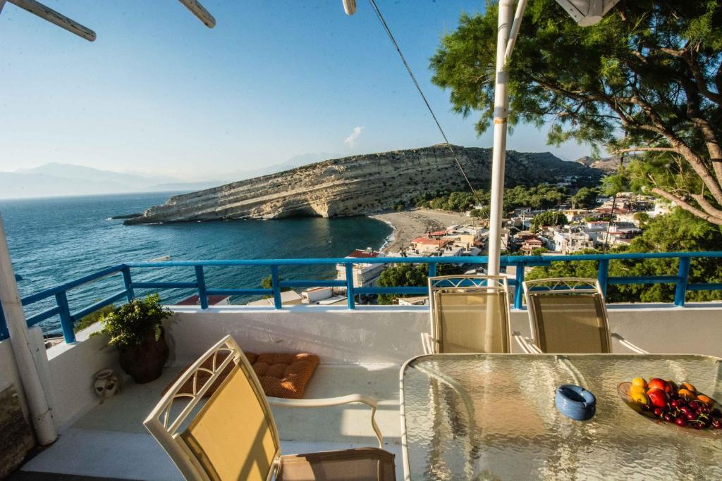 a balcony with a table and chairs overlooking the ocean at Castri House in Matala