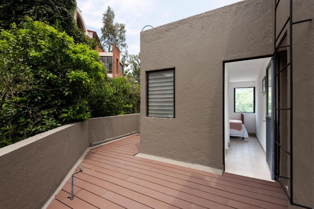 a house with a wooden walkway next to a building at Cuarto en las Lomas in Mexico City