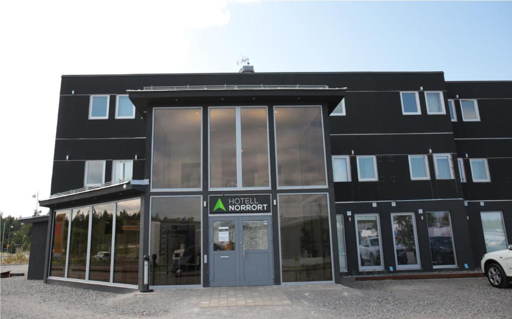 un bâtiment noir avec une porte devant lui dans l'établissement Hotell Norrort, à Vallentuna