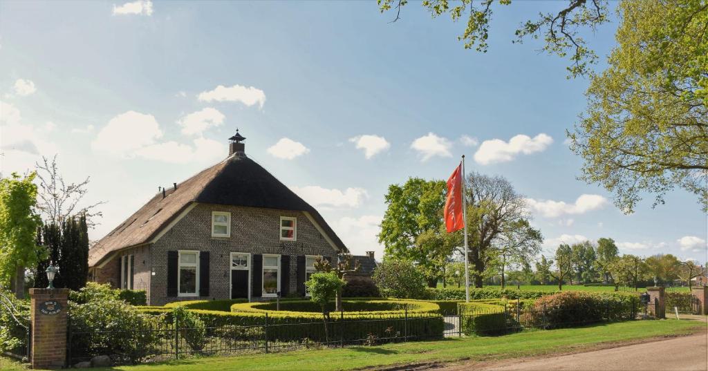 ein Haus mit einer Flagge davor in der Unterkunft De Beddestee in Ruinen