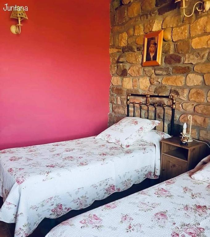A bed or beds in a room at Casa Rural Juntana
