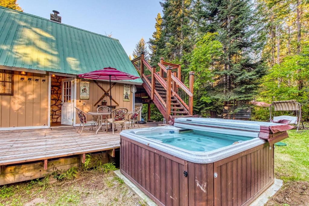 a house with a hot tub on a wooden deck at Whispering Pines in Leavenworth