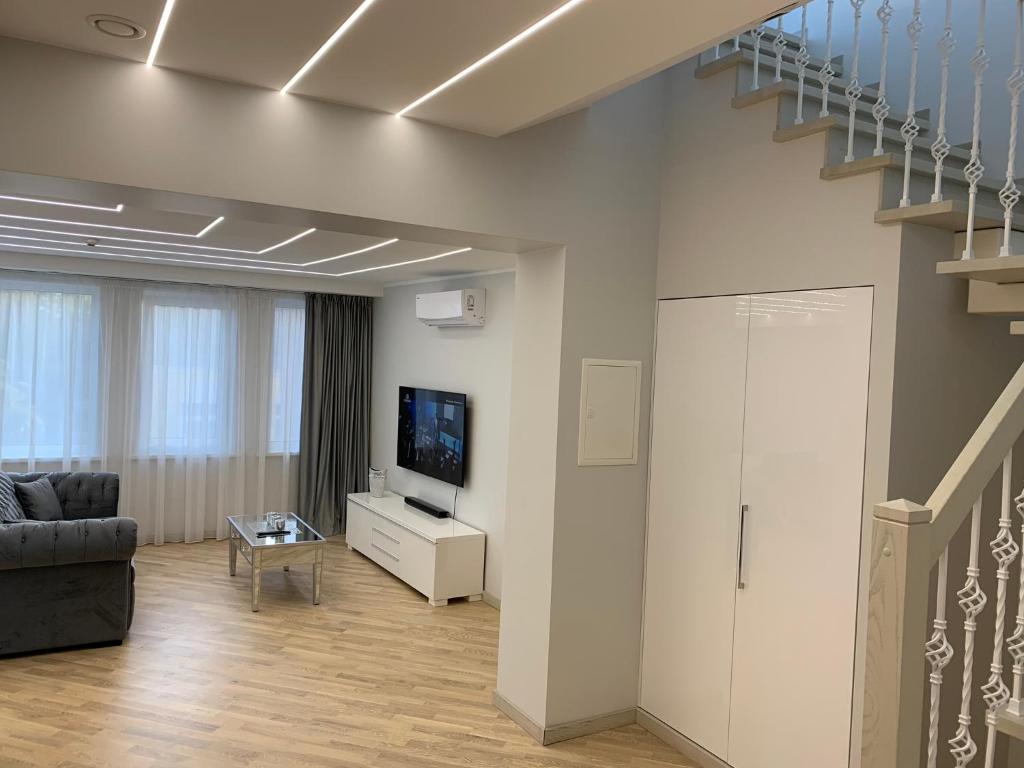 a living room with a couch and a television at Roof terrace apartment in Panevėžys