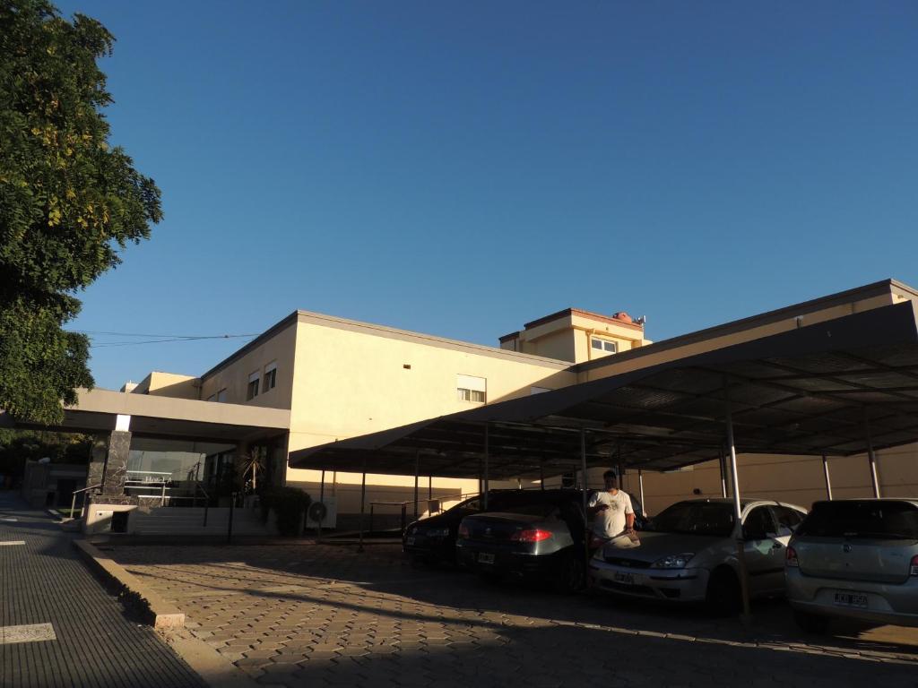 a parking lot with cars parked in front of a building at Hotel Algarrobo in Merlo