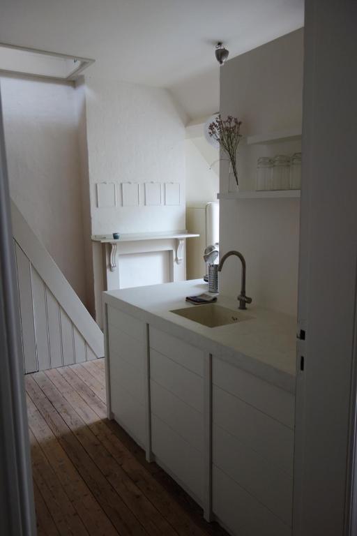 una cucina con lavandino e armadietti bianchi di Studio Minerva ad Anversa