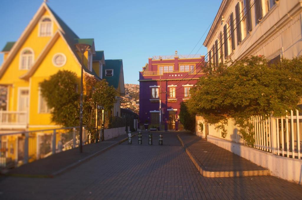 a city street with colorful houses and a fence at Hotel Manoir Atkinson in Valparaíso