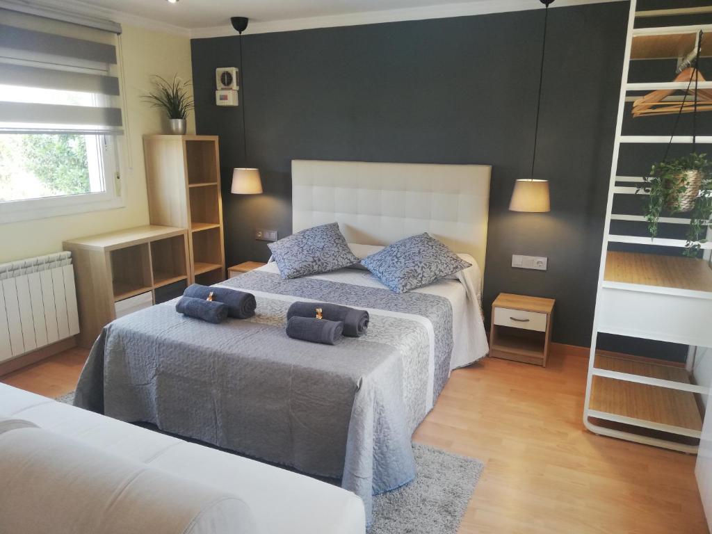 a bedroom with two beds with blue pillows on them at LOFT A 20' DE BARCELONA Y 7' DE LA UAB. in Barbera del Valles