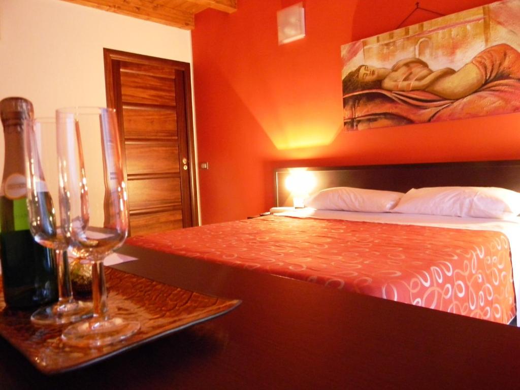 パレルモにあるB＆B オレート チェントロのベッドルーム1室(ベッド1台、ワイングラス付きのテーブル付)