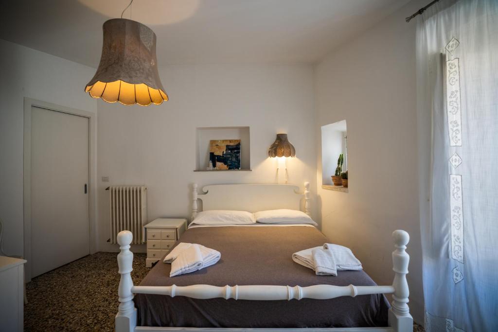 a bedroom with a bed and a chandelier at Bianko EcoChic & L'Angolo di Levante in Enna