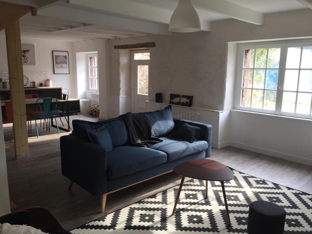 a living room with a blue couch and a table at Maison familiale Groix in Groix