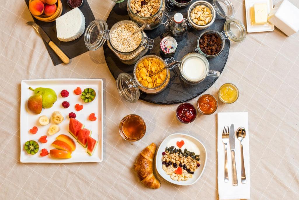 a table topped with plates of food and glasses of milk at Chalet Diognysos B&B, Boutique Hotel & Wellness in Crans-Montana