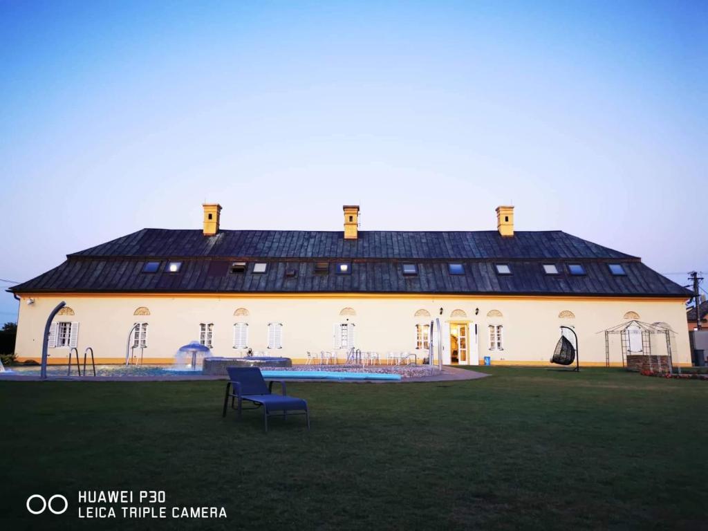 un grand bâtiment blanc avec un toit noir dans l'établissement Majerovský kaštieľ, à Vranov nad Topľou