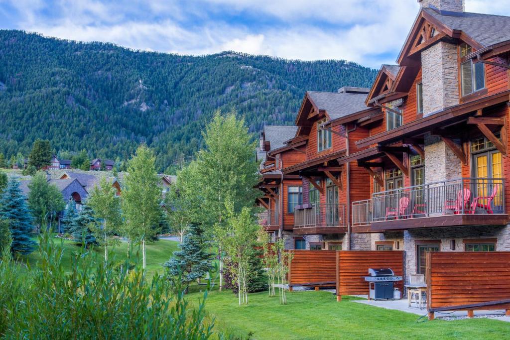 a log home with a mountain in the background at Spanish Peaks Condo 20 in Big Sky