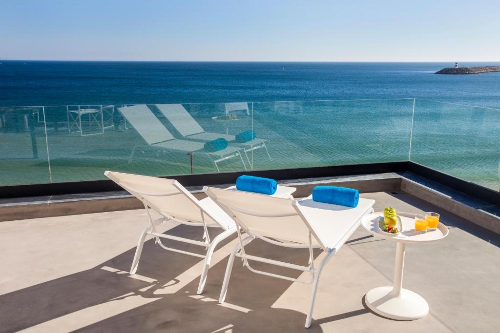 een balkon met een tafel en stoelen en de oceaan bij Season Apartments in Sesimbra