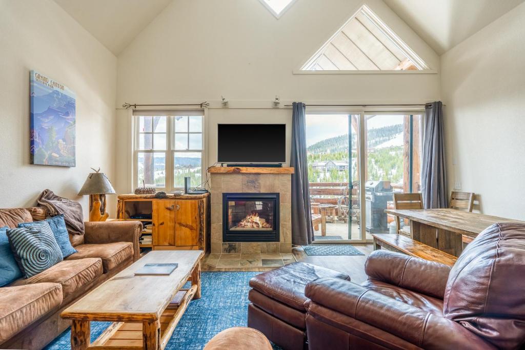 Una sala de estar con un sofá y una chimenea. en Saddle Ridge G4, en Big Sky