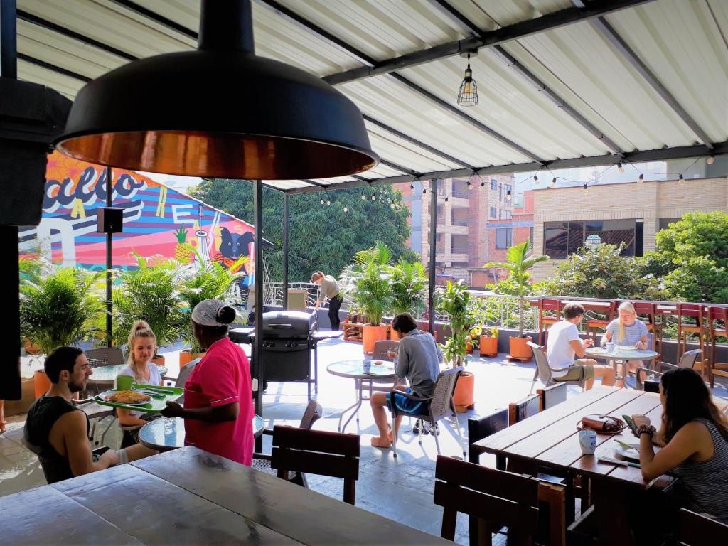 a group of people sitting at tables in a restaurant at Noah boutique hostels Medellín in Medellín